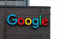 Colorful Google logo displayed on a brick wall of a building