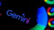 Close-up of the Gemini logo illuminated in colorful lights against a dark background.