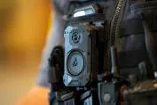Close-up of an Axon body camera attached to a tactical vest.