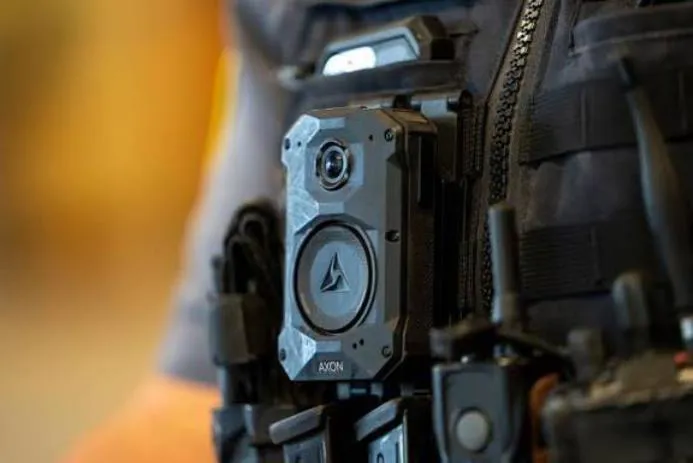 Close-up of an Axon body camera attached to a tactical vest.