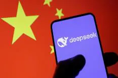 A hand holding a smartphone displaying the DeepSeek logo against the backdrop of the Chinese flag.