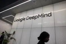 Entrance sign of Google DeepMind with a person walking past