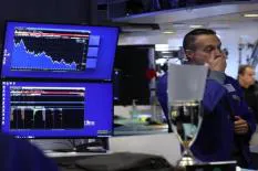 A stock market trader monitoring financial data on screens, with charts showing market trends and analysis.