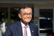 smiling-asian-american-man-navy-suit-glasses-us-flag-pin-professional-portrait